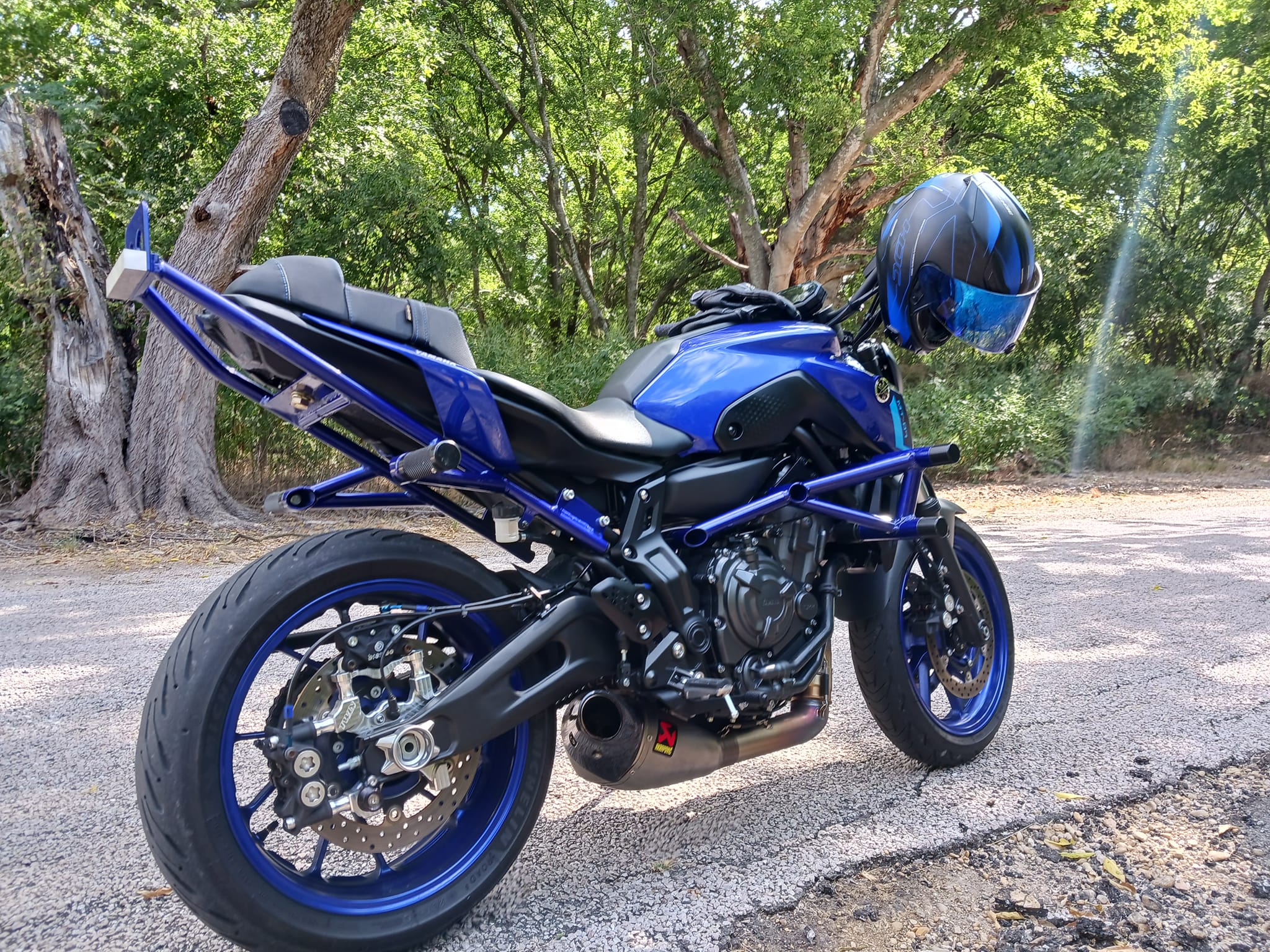 Blue Yamaha MT-07 with stunt modifications parked under trees